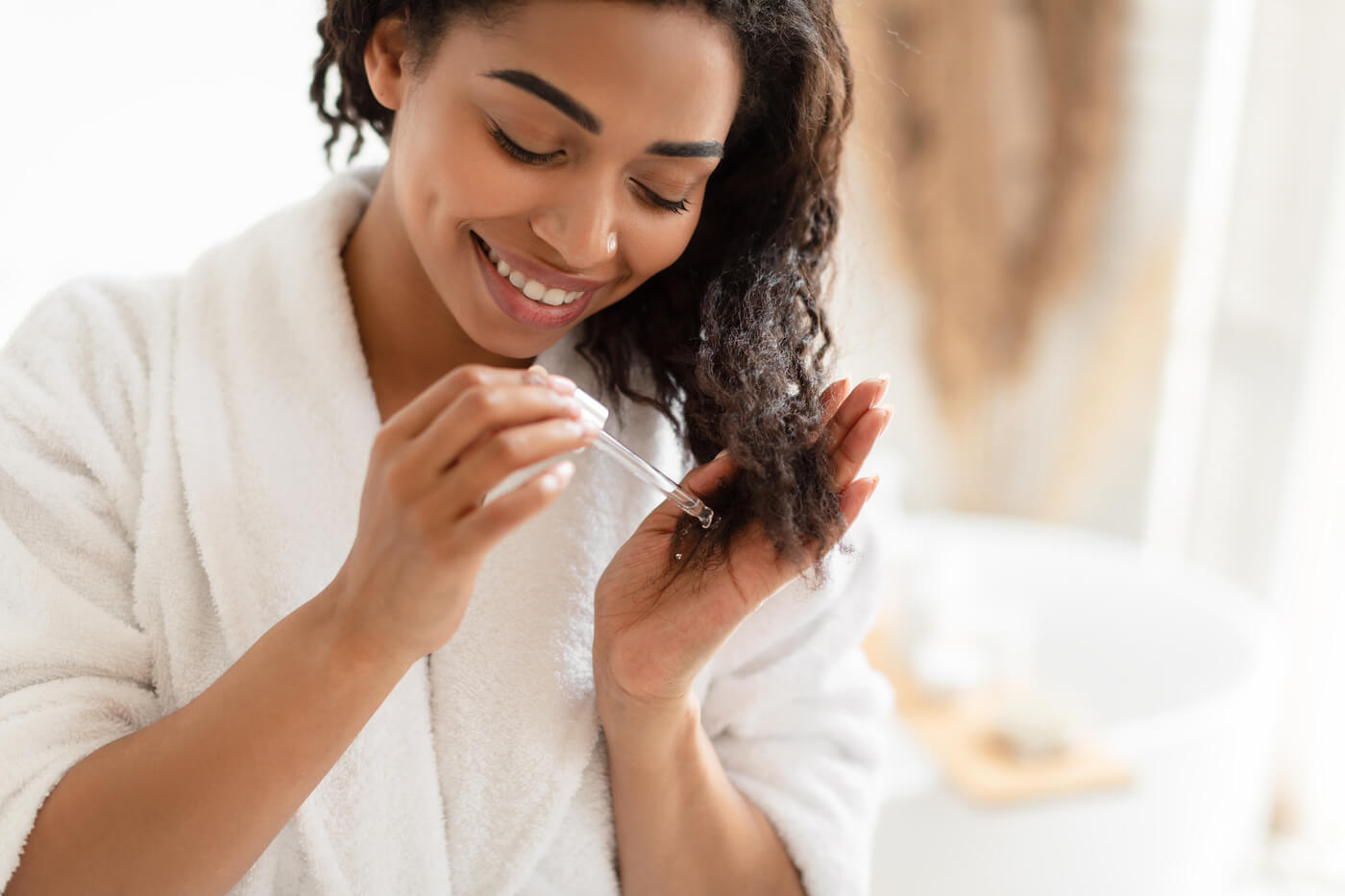 Woman using an eyedropper to add essential oils to her hair