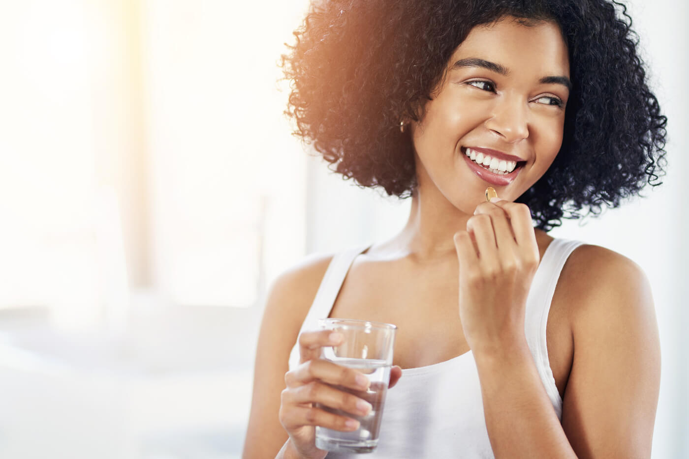 Woman taking a Vitamin E supplement